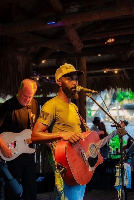 Jesse Daniels singing with a red acoustic guitar beside his guitarist