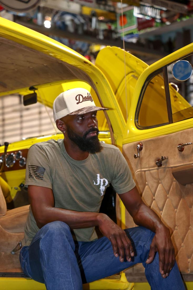 Jesse Daniels seated in a vintage yellow car