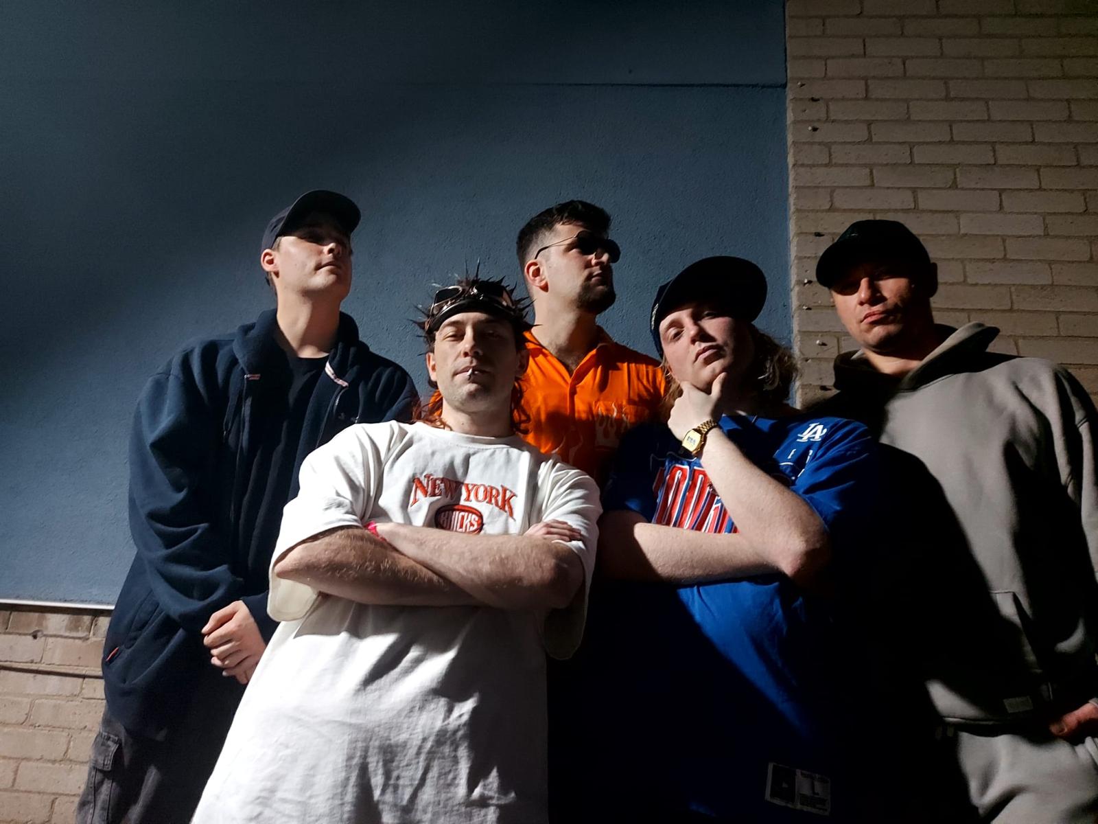 Velour Fog band members posing against a blue wall