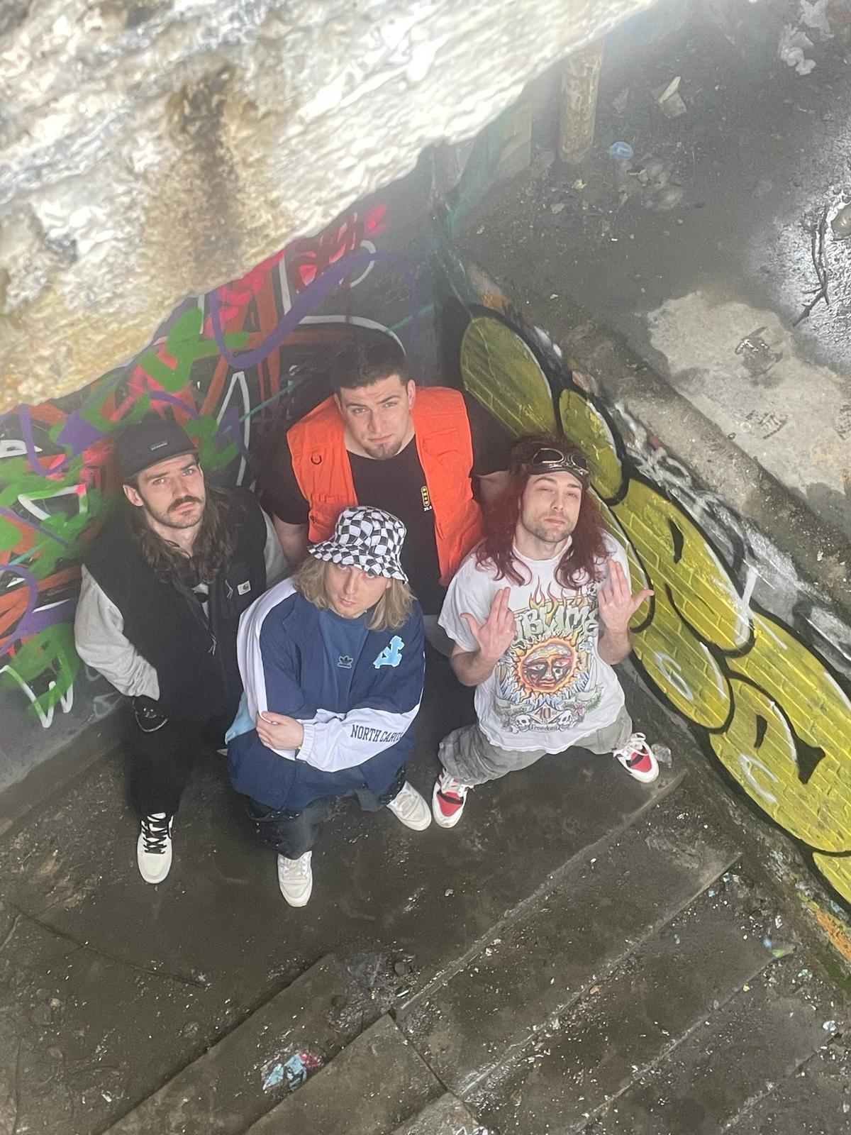 Velour Fog band members photographed from above against a graffiti wall