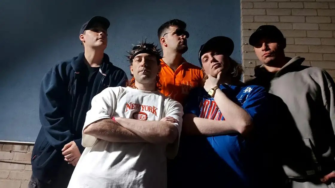 Velour Fog, British rock band, posing against a blue wall